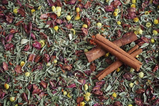 Brown cinnamon sticks on a beautiful background of herbs and flowers