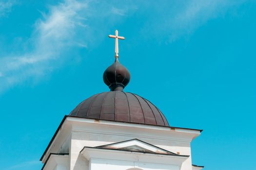 The dome of the chapel with a golden cross against the blue sky. Laspi, Crimea