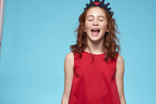 Girl in red dress with curly hair fun lifestyle blue background. High quality photo