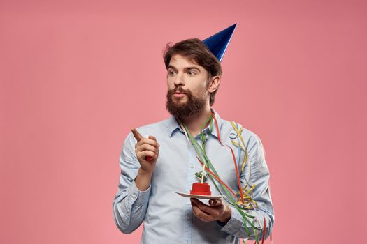 Happy car with a cake on a pink background and in a cap in Copy Space holidays birthday. High quality photo