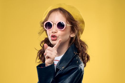 Girl in a yellow hat dark glasses fashionable clothes studio lifestyle childhood. High quality photo