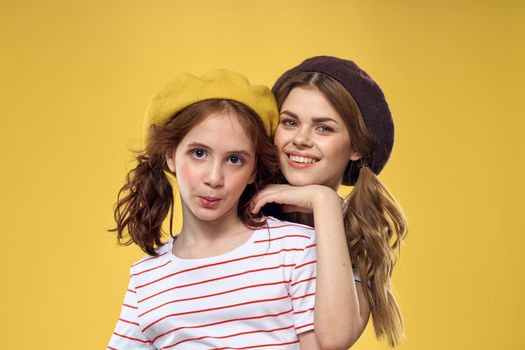 Mom and daughter embrace joy fun childhood lifestyle yellow background. High quality photo