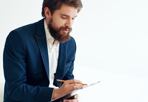 A man in a jacket and shirt with documents on his knees. High quality photo