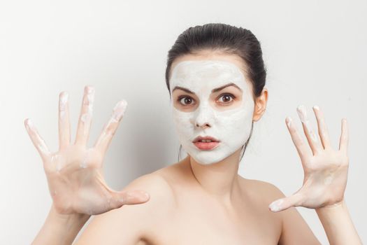 pretty brunette with cream face mask bare shoulders smile cropped view. High quality photo
