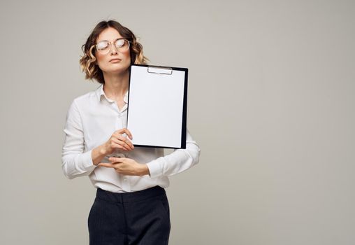 Business woman in a shirt holds a folder with a white sheet of paper Copy Space. High quality photo