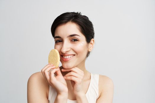 Pretty brunette clean face skin Sponge in hands with cosmetics. High quality photo