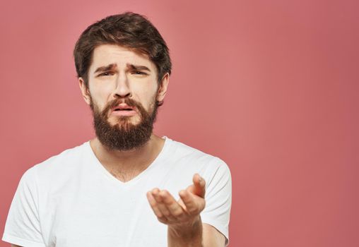 Man on pink background emotions model cropped view puzzled look sad face. High quality photo