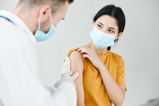 a nurse gives a shot to a woman's shoulder vaccination infection epidemic. High quality photo