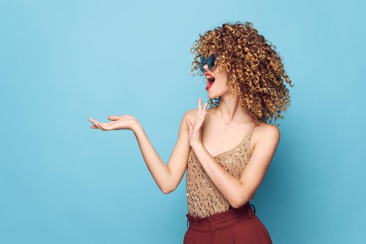 Pretty woman Curly hair gesture with hands blue background studio bright makeup isolated background