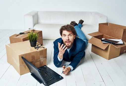 Man in suit with boxes moving laptop lifestyle Professional. High quality photo