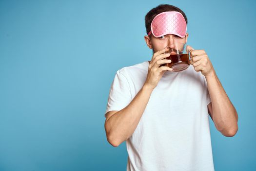 A man in a white T-shirt drinks tea at home in the morning. High quality photo