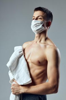 sport man medical mask safety white towel on shoulders . High quality photo