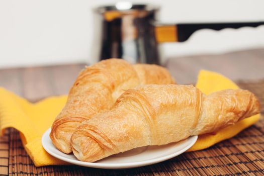 crispy croissants on a plate kitchen utensils for breakfast . High quality photo