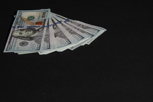 The American dollar. Paper bills of a hundred dollars on a black background. High quality photo