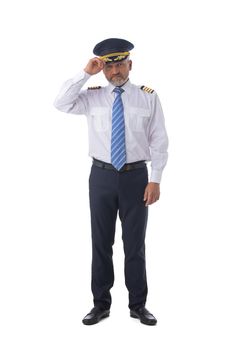 Airline pilot salute touching cap wearing the four bar Captains epaulettes, first pilot, aircraft commander, isolated on white background, full length portrait