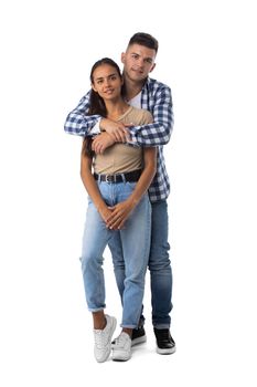 Smiling young couple embracing and standing full length isolated on white background