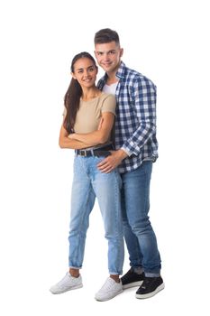 Smiling young couple embracing and standing full length isolated on white background