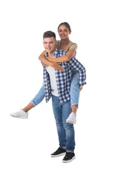 Young happy couple with her at piggyback ride isolated on white background, casual people