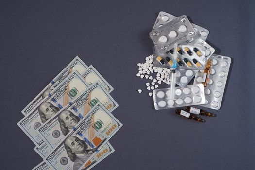 Banknotes, the US dollar, and medicines. The concept of the cost of medicines. High quality photo