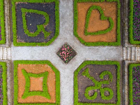 Aerial drone top down look to Small square in park with plants in card symbols shape