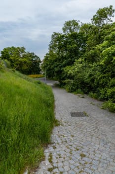 Long brick path to down of small hill at cloudy day