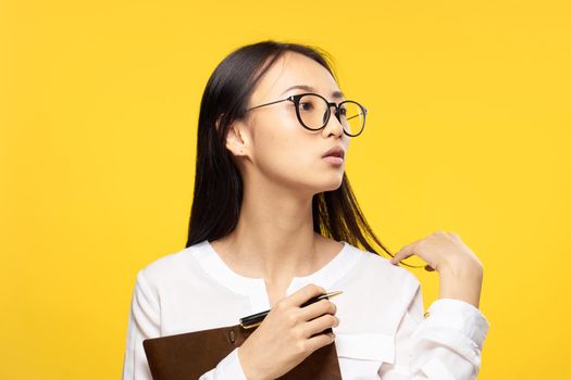 woman of asian appearance white shirt notepad in hands work manager. High quality photo