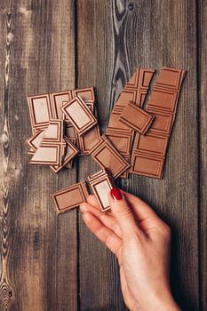 bar of chocolate broken into cubes on a wooden table. High quality photo