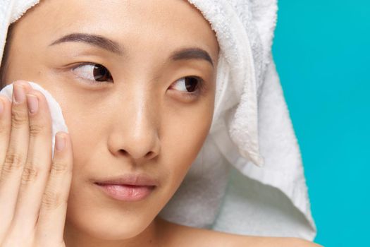 woman asian appearance clean skin close-up spa treatment blue background. High quality photo