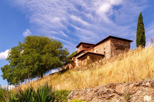 Wide shot of an old church on top of a hill against the blue sky on a sunny day