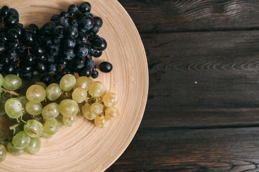 grapes on a plate fruit wooden background vitamins. High quality photo