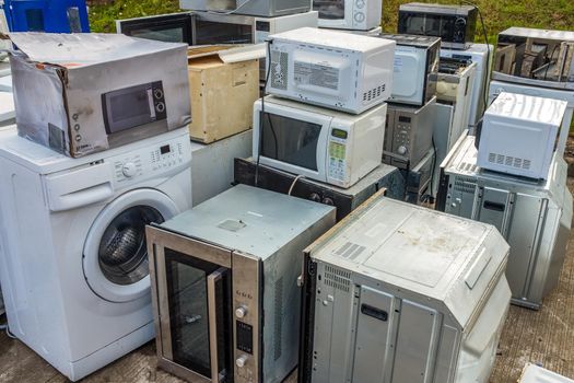 A Collection Of Domestic Applicance (Ovens, Microwaves And Washing Machines) Left At A Dump Or Recycling Center