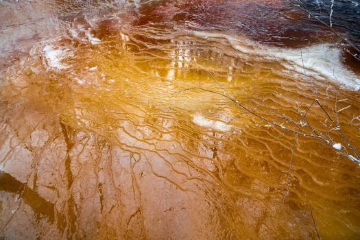 Drawings of winter on the frozen river, the reflection of trees on an ice smooth surface, the wild frozen small river in the winter wood, the wild nature at sunset, the river of red color, ice. High quality photo