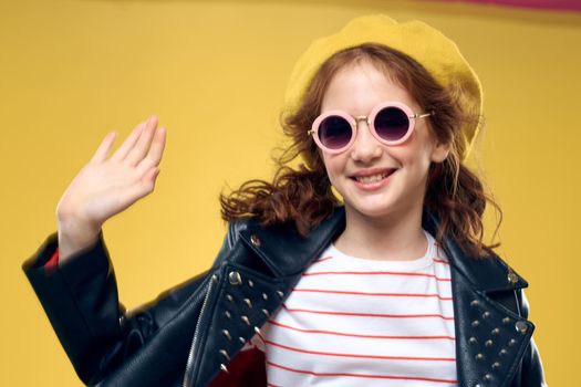 Girl in a yellow hat dark glasses fashionable clothes studio lifestyle childhood. High quality photo