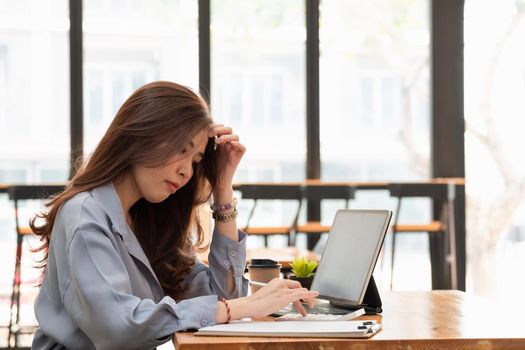 Asian woman working with tablet while reading data on notebook. Student girl working at home. Work or study from home, freelance, business, lifestyle concept.