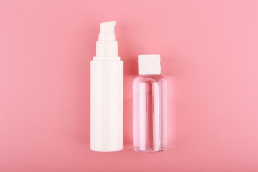 Set of cosmetic bottles for face cream or lotion and skin lotion or gel against pink background. Concept of skin care and beauty. 