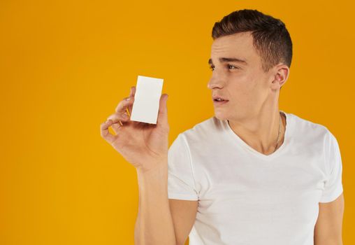 guy with a white card on a yellow background Copy Space mockup. High quality photo