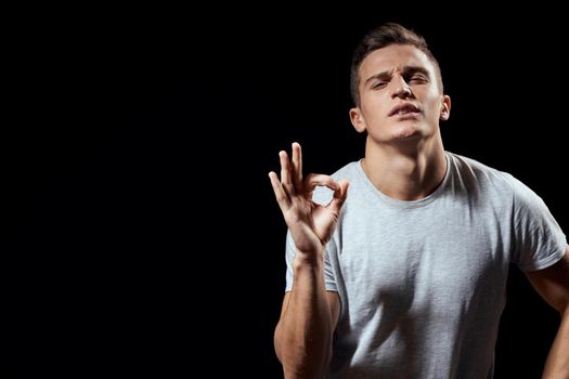 Cheerful man white t-shirt gesture with hands black background sport. High quality photo