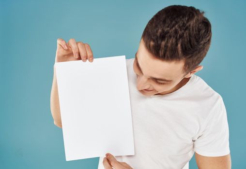 Man with white sheet of paper poster blue background mockup. High quality photo