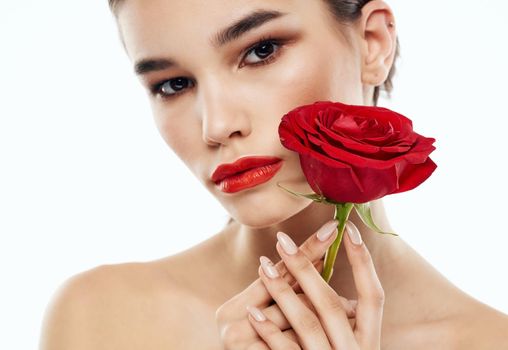 Portrait of romantic people with bare shoulders and a red flower in front of their eyes. High quality photo