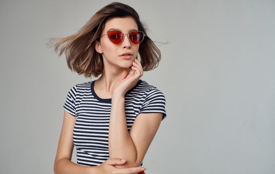 romantic woman in striped t-shirt portrait on gray background and fashionable glasses on face. High quality photo