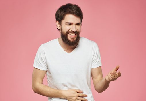 Emotional man gesturing with his hands on a pink background cropped view. High quality photo