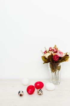 bouquet of fragrant flowers and Easter eggs on a wooden table In a bright room. High quality photo