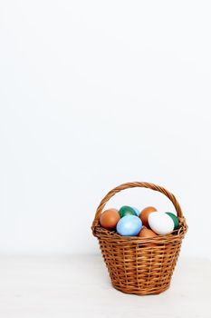 Easter eggs in a basket on a light background and church holiday. High quality photo