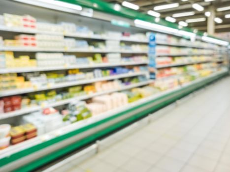 Blurred supermarket aisle with colorful shelves of merchandise. Perspective view of abstract supermarket aisle with copy space in center, can use as background or retail concept
