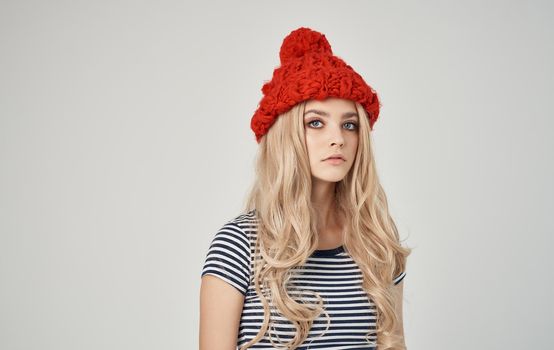 emotional blonde woman in striped t-shirt with cap on her head on phone cropped view. High quality photo