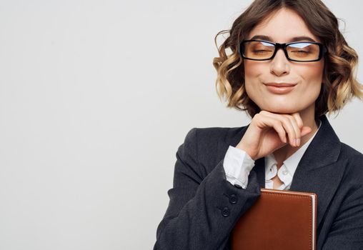 Woman secretary in a classic suit with glasses on her face and documents in her hand. High quality photo