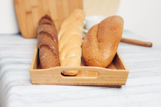 fresh loaves on a breadbasket on the table breakfast kitchen meal. High quality photo