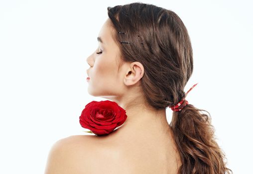 sexy woman with red flower on shoulder on light background cropped back view. High quality photo