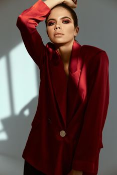 pretty woman holding hand on her head red jacket fashion posing Studio. High quality photo