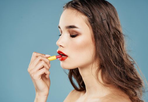 Sexy brunette with bright makeup and lipstick blue background. High quality photo